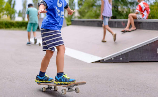 Barn på skateboard i en skatepark i gang med at lære begynder trick og balance